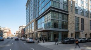 A modern hotel facade located on a busy downtown street with a clear sky