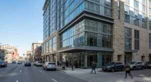 A modern hotel facade located on a busy downtown street with a clear sky